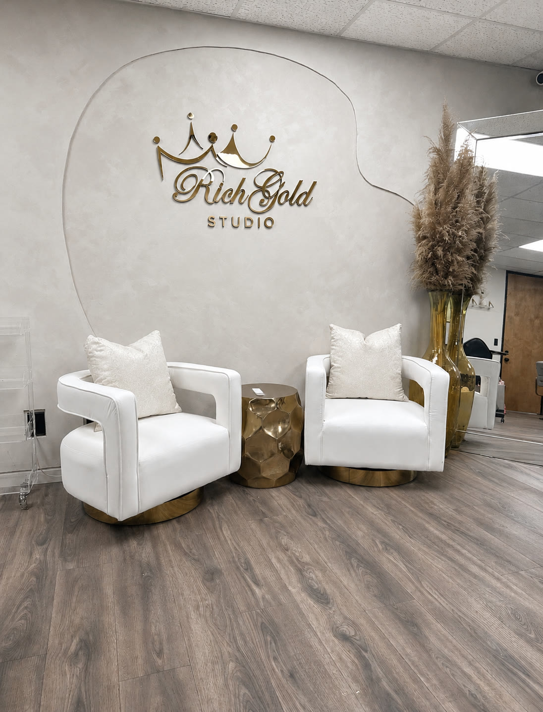 The esthetics station: a black treatment bed under a curved arch lamp, with a rolling stool, a tray and a sink cabinet.